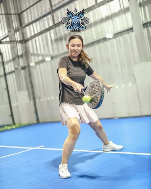 A smiling player hitting a forehand